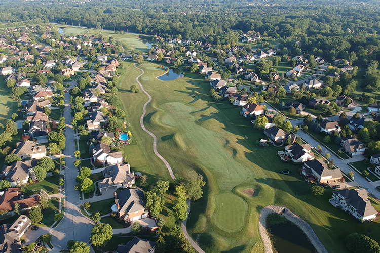 aerial view of neighborhood with course